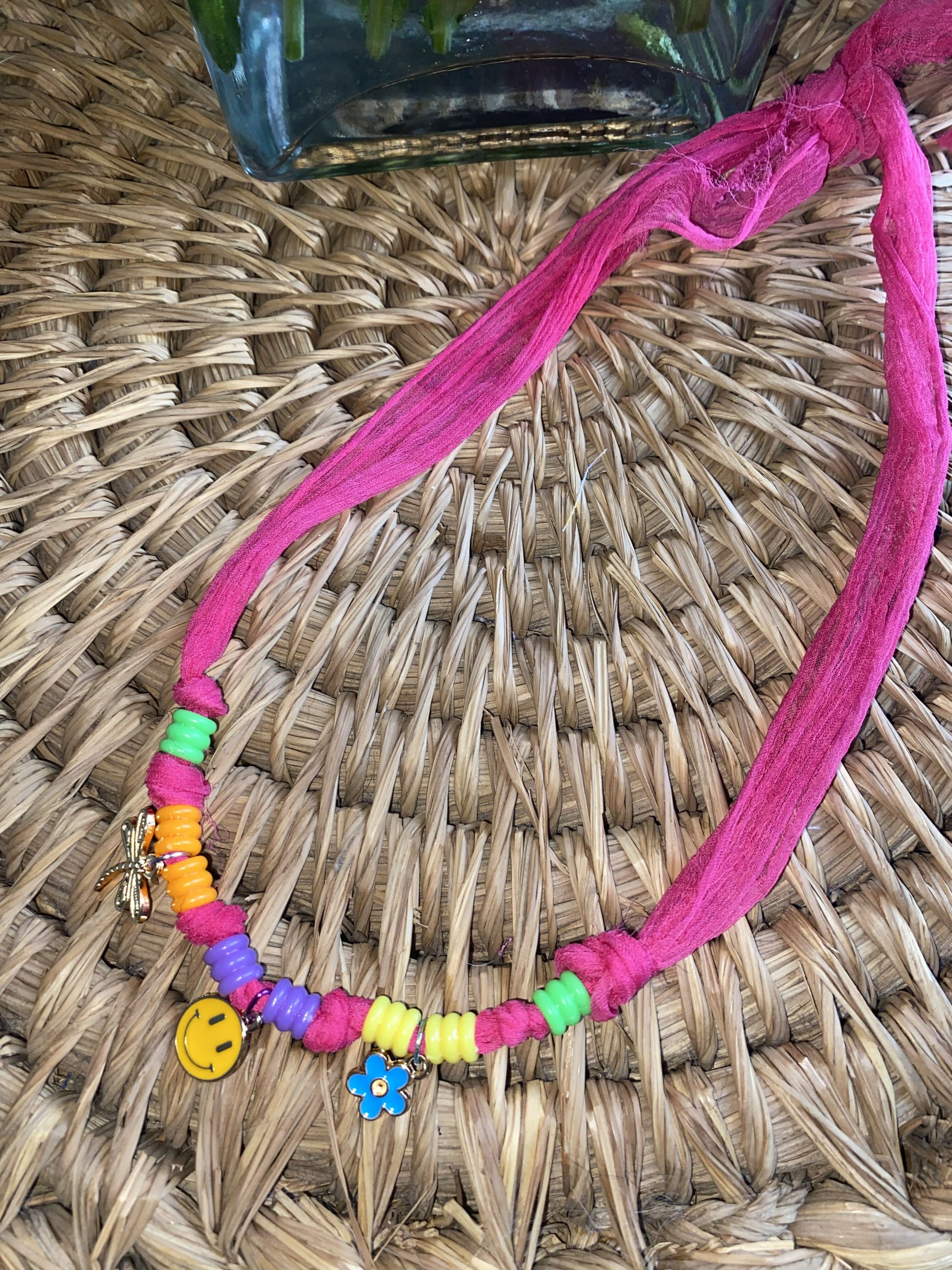 Bright colored stretchy pink necklace with charms